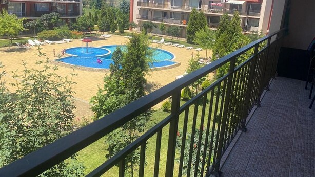 Ein Wohngebäude mit Schwimmbad, mehreren Balkonen und Blick auf die Umgebung.