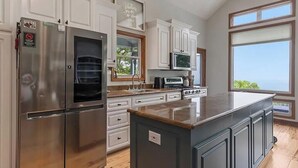 Una cocina moderna con electrodomésticos de acero inoxidable, armarios blancos y una isla grande.