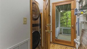Un cuarto de lavado con puerta de madera, lavadora y secadora.