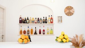 A bar area with shelves of liquor bottles, a clock, and a fruit bowl. - Villa Rossa (Agerola)
