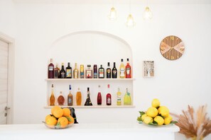 Eine Bar mit Regalen voller Spirituosenflaschen, einer Uhr und einer Schale Orangen.