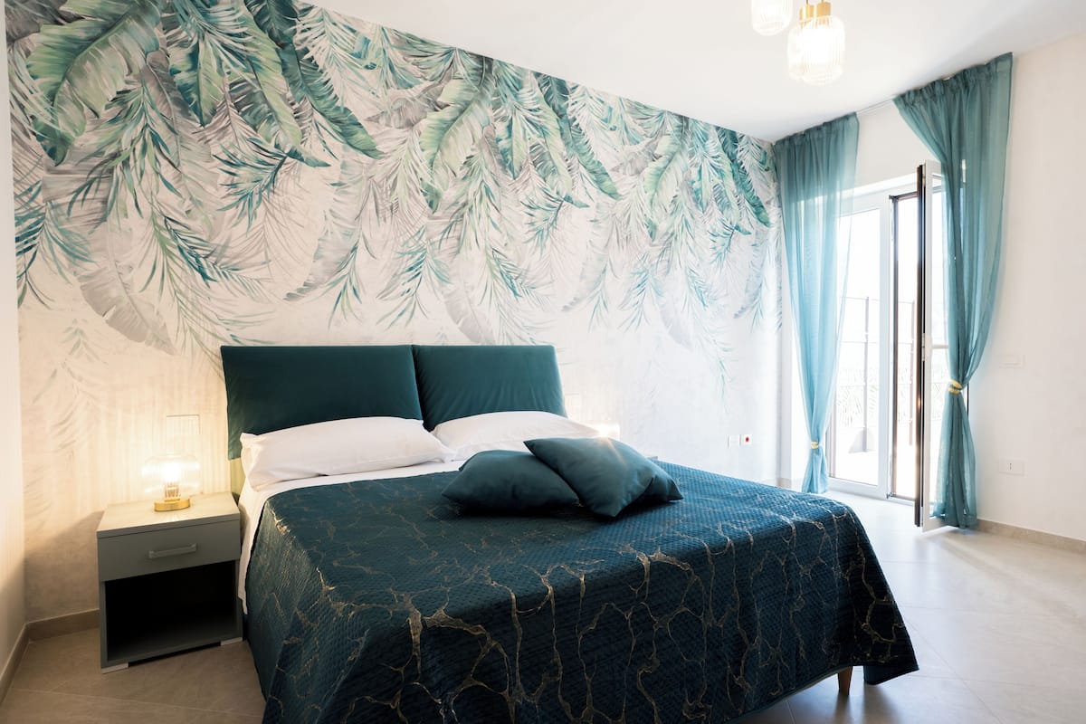 Une chambre à coucher avec un lit, une table de chevet et une fresque murale.