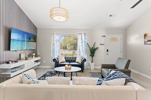 A living room with a sofa, a coffee table, a TV, and a door labeled 'KEYS'.