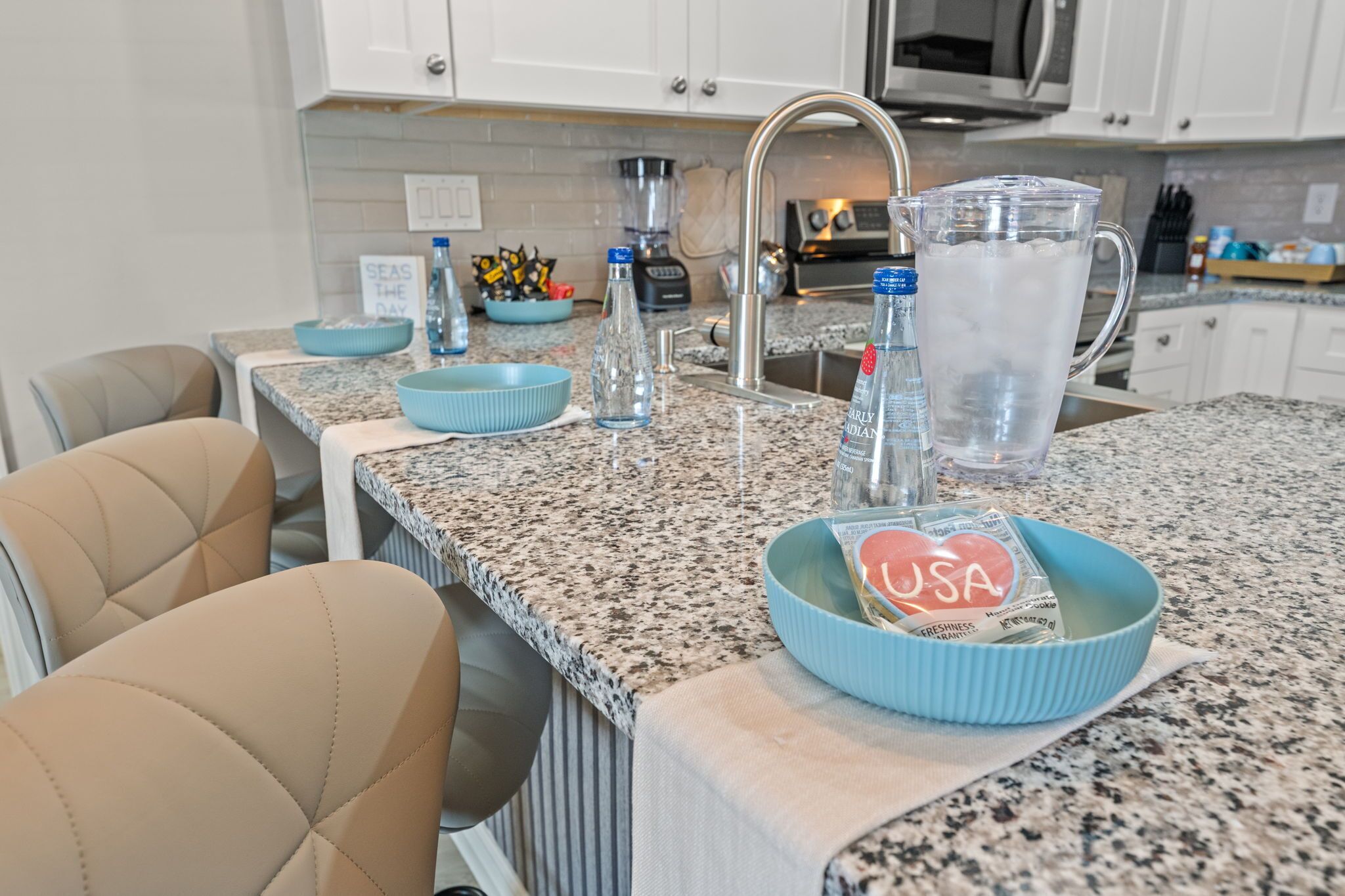 A kitchen with granite countertops, a sink, a microwave, and a coffee maker.