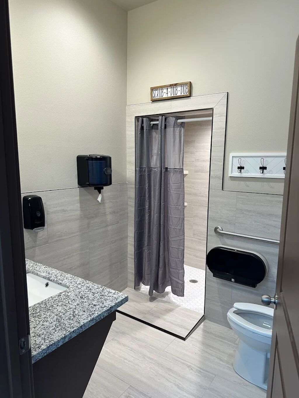 Un bagno moderno dotato di doccia, WC e lavabo.