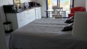 A bedroom with a bed, a desk, a chair, and a view of the outdoors. - STUDIO sea and cape view 2pers. (Erquy)