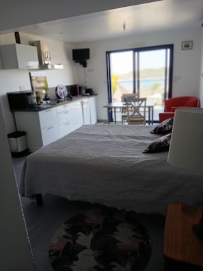 A bedroom with a bed, a desk, a chair, and a view of the outdoors. - STUDIO sea and cape view 2pers. (Erquy)