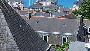 A coastal town with buildings, a harbor, and a hill in the background. - STUDIO sea and cape view 2pers. (Erquy)
