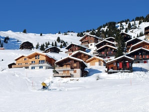 A cluster of wooden chalets on a snowy mountain slope with clear skies. - Alpine Hideaway in Les Angles (Les Angles)