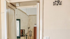 A room with a dining table, chairs, a wooden dresser, a mirror, and a patterned rug. - The House of Aunts - Maglie (Maglie)