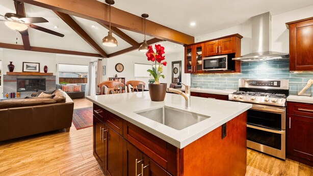 A modern kitchen with a large island, wooden cabinets, stainless steel appliances, and a ceiling fan. - 25% Off Sept WkDay Great 4 Families, Walk 2 Beach! (Ventura)