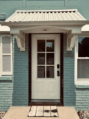 A house with a white front door, a small porch, and a mailbox. - Lake Breeze Stylish Beach Boho 1BD w/ Private Deck (Michigan City)