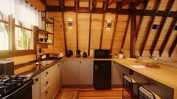 A kitchen with wooden beams, a stove, cabinets, a refrigerator, and a window with curtains.