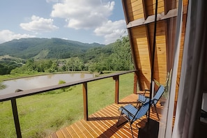 A wooden deck with a view of a lake and mountains.