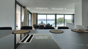 Uma sala de conferências moderna com uma mesa grande, cadeiras e vista para o mar.