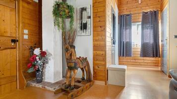 Interior de madera con una escultura de caballo, una pequeña escalera y una puerta con cerradura de llave.