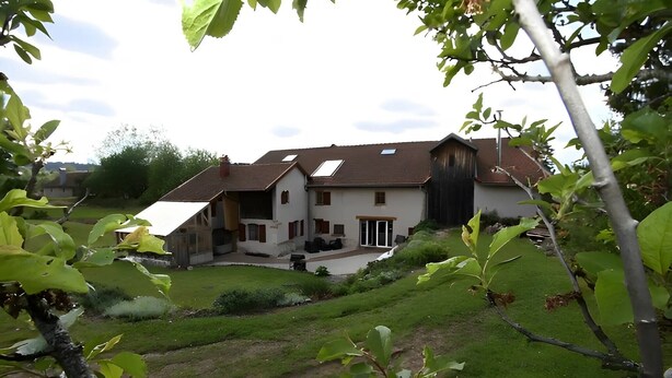 A two-story house with a large patio, a garage, and a fenced yard.