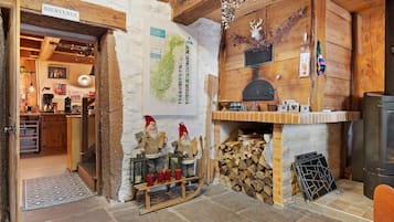 A rustic interior with a wooden fireplace, a map on the wall, and a rustic wooden bench.