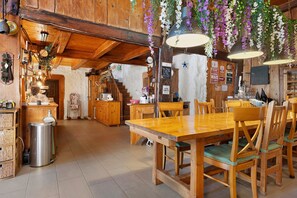 Ein rustikales Holzinterieur mit Esstisch, Stühlen und einer Küchenzeile.