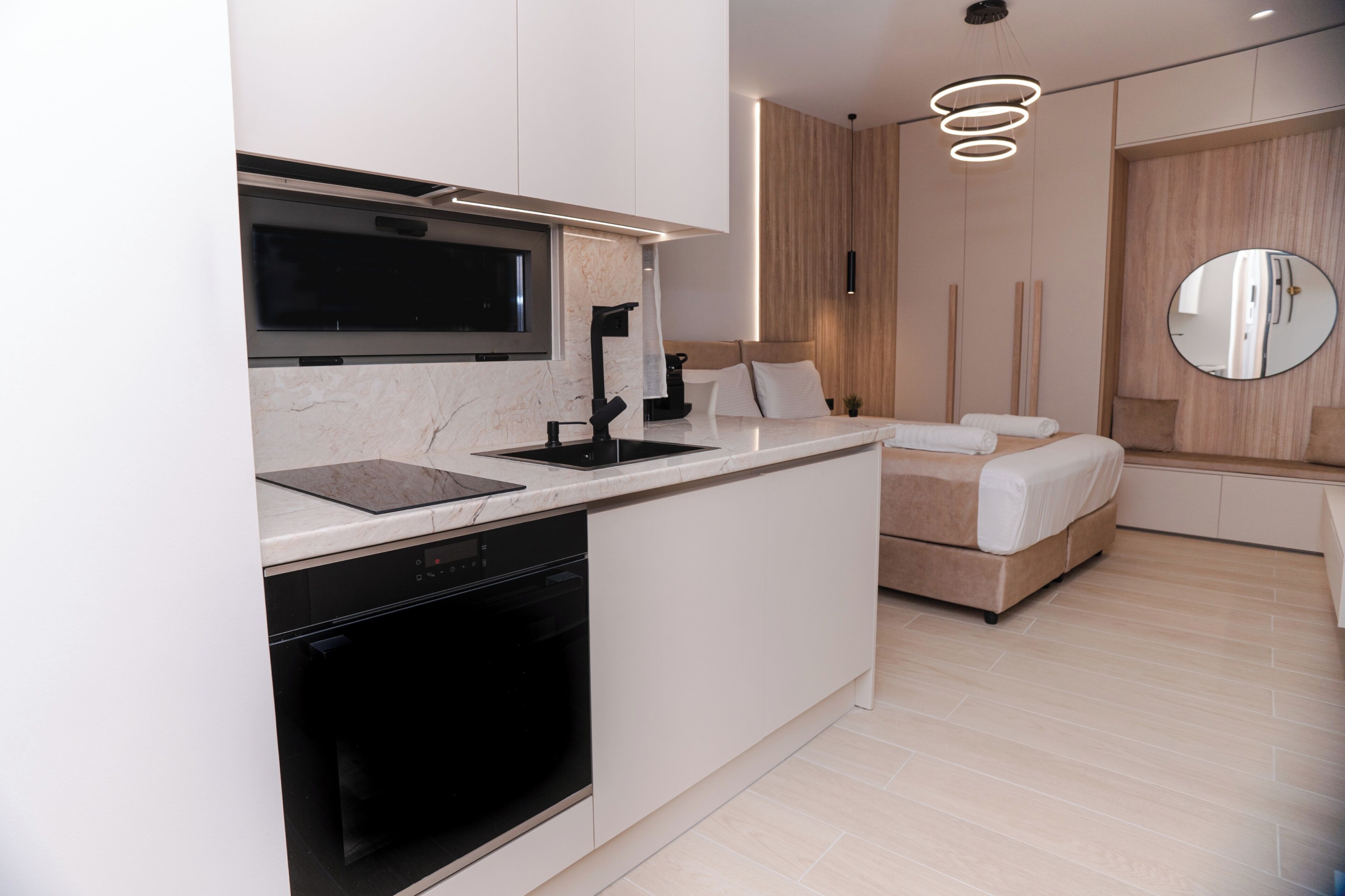 A modern kitchen with a built-in oven, a microwave, and a large island with a sink.