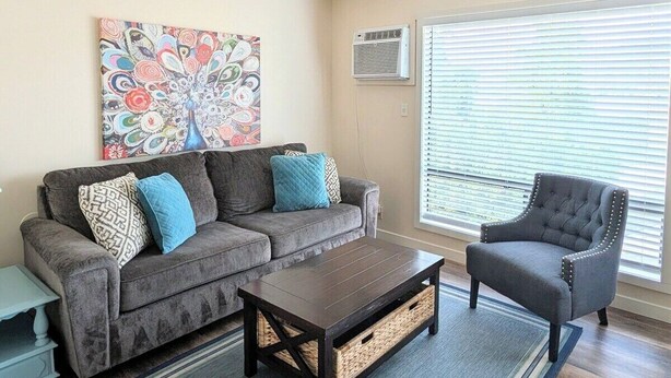 A living room with a sofa, armchair, coffee table, and a decorative wall piece. - Turquoise Tide Retreat, Top Floor, Steps to Lake (Chelan)
