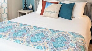 A bedroom with a bed, a nightstand, a lamp, and a wall painting. - Turquoise Tide Retreat, Top Floor, Steps to Lake (Chelan)