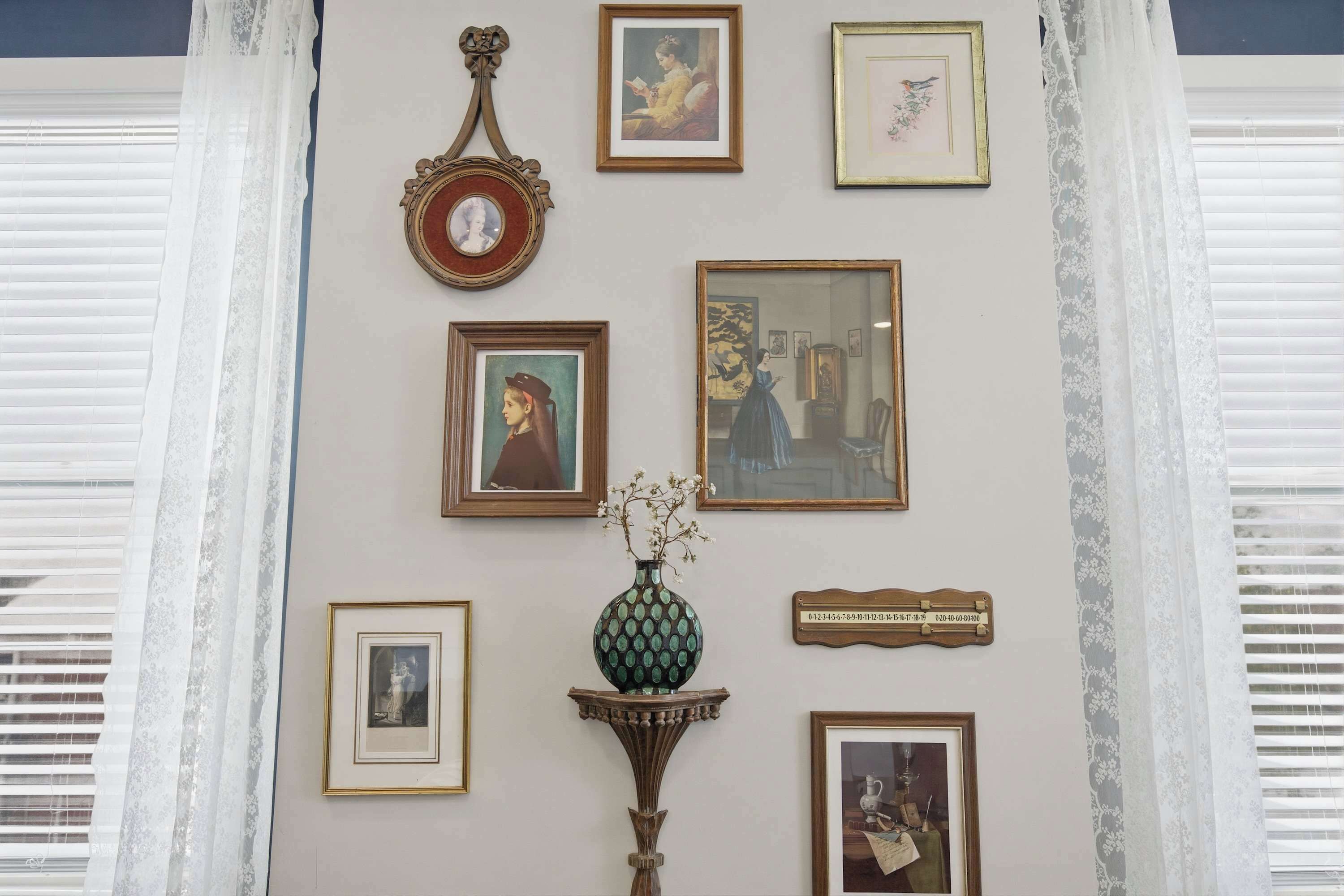 Un mur orné de tableaux encadrés et d’une horloge.