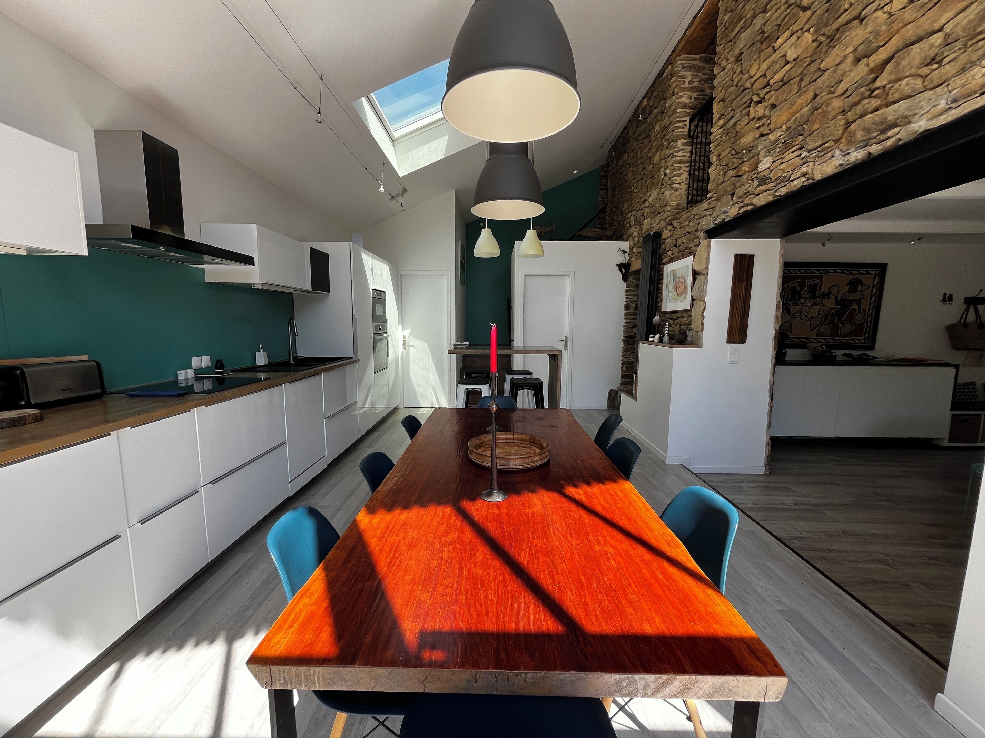 Eine moderne Küche mit weißen Schränken, einem Holzespeisetisch und blauen Stühlen.