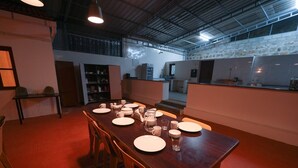 Un comedor con una larga mesa de madera dispuesta para seis personas, rodeada de sillas.