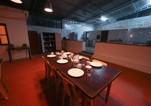Un comedor con una larga mesa de madera dispuesta para seis personas, rodeada de sillas.