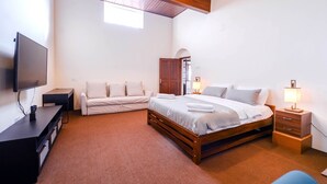 A bedroom with a bed, a TV, a desk, a chair, and a lamp. - Lauriston Villa Ooty by VOYE HOMES (Ooty)