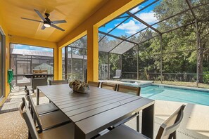 A covered outdoor area with a pool, a grill, and a dining table with chairs. - Pvt Pool&Spa·Game Room·BBQ·Near Theme Parks (Kissimmee)