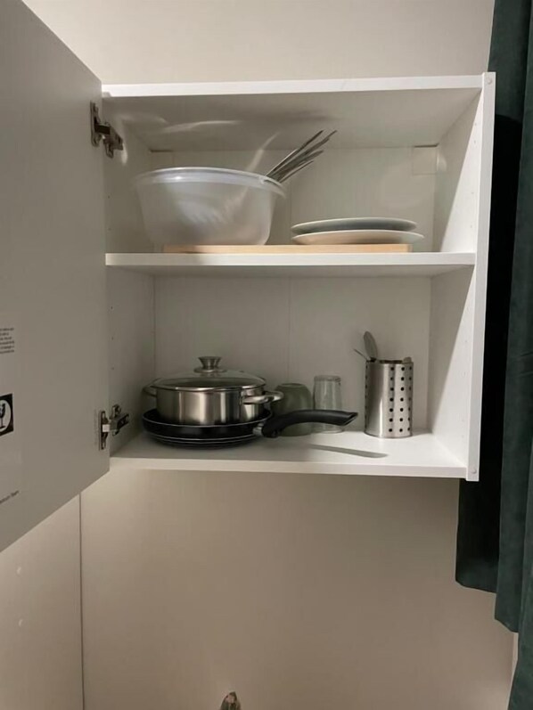 Una cocina con una olla sobre la estufa, un tazón en la repisa y un organizador para cuchillos.