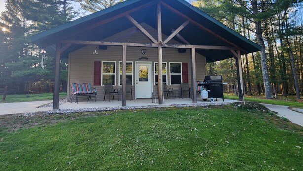 Un pavillon couvert doté d’une porte, de fenêtres et d’un barbecue.
