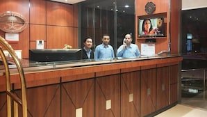 Una recepción con detalles de madera, un reloj y una pantalla de televisión.