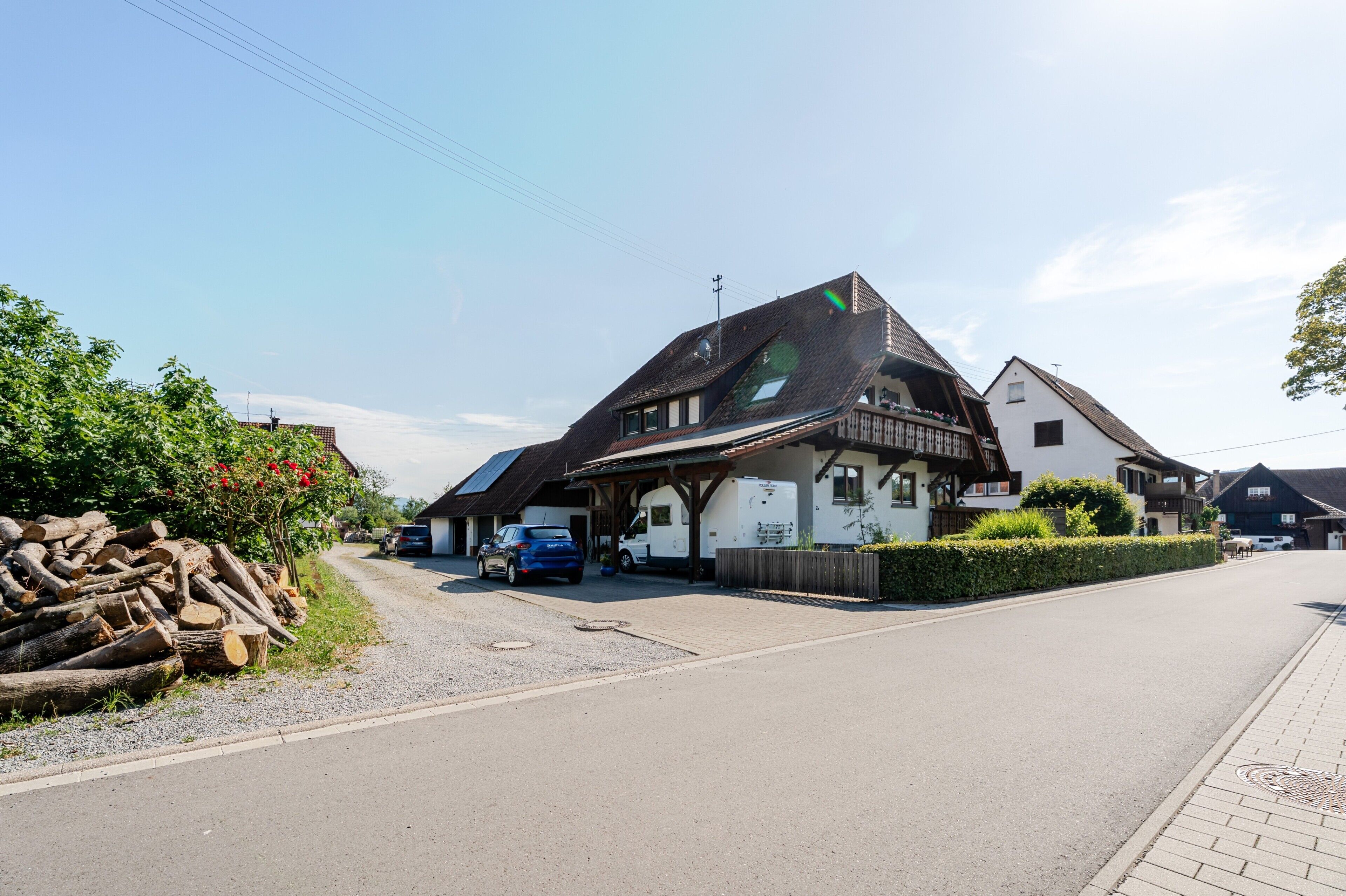 Ein traditionelles Gebäude im europäischen Stil mit Satteldach, einer sichtbaren Garage und einem gepflasterten Einfahrt.