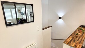 A modern kitchen with a wooden countertop, a built-in stove, and a white radiator. - Cozy 1-bedroom apartment with AC and a jetted tub in gorgeous Strasbourg (Strasbourg)