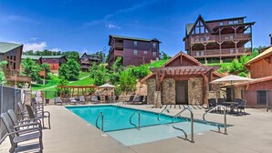 A pool area with lounge chairs and a clear blue pool. - NEW Lux 4 BR Pigeon Forge Dollywood Hot Tub (Pigeon Forge)
