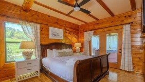 A wooden-paneled bedroom with a bed, nightstand, and window with curtains. - NEW Lux 4 BR Pigeon Forge Dollywood Hot Tub (Pigeon Forge)