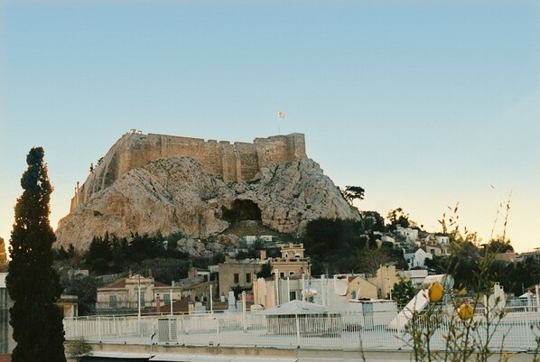 Une fortification historique, surmontée d’un drapeau, entourée d’immeubles d’habitation et d’une clôture blanche.