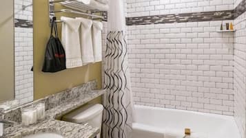 Un baño con inodoro blanco, lavabo, bañera y cortina de ducha.