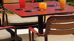 Una mesa con cuatro bebidas y dos sillas.