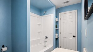 Une salle de bain avec une baignoire, des toilettes, un lavabo et une porte.