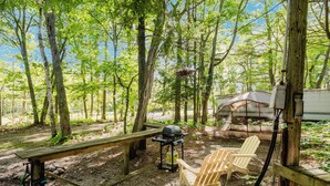 A campsite with a picnic table, a grill, and a tent. - Tiny House (Nobel)