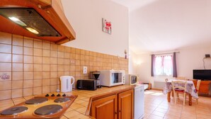 A kitchen with a stove, microwave, toaster, and refrigerator. - Gite Le Micocoulier La Fontinelle – Modern Holiday Home in Peaceful Ardèche Nature (Bessas)