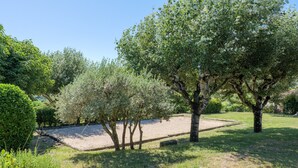 Un parc avec des arbres, un chemin de gravier et une pelouse.