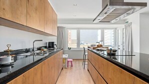 Eine moderne Küche mit Holzausstattung, einer schwarzen Arbeitsplatte und einem Fenster mit Blick auf die Stadt.