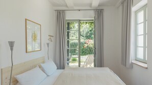 A bedroom with a bed, a window, and a view of a garden. - Art Deco villa with Havel views in historic Werder (Werder (Havel))