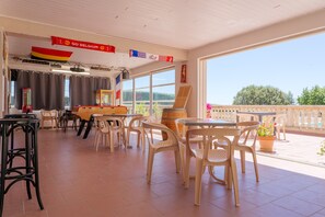 Ein Restaurant mit Außenbestuhlung, Blick zum Himmel und einer Flagge.