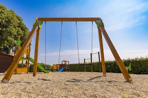 A wooden swing set with a gravel ground. - Holiday Home “L’Olivier - La Fontinelle” (Bessas)